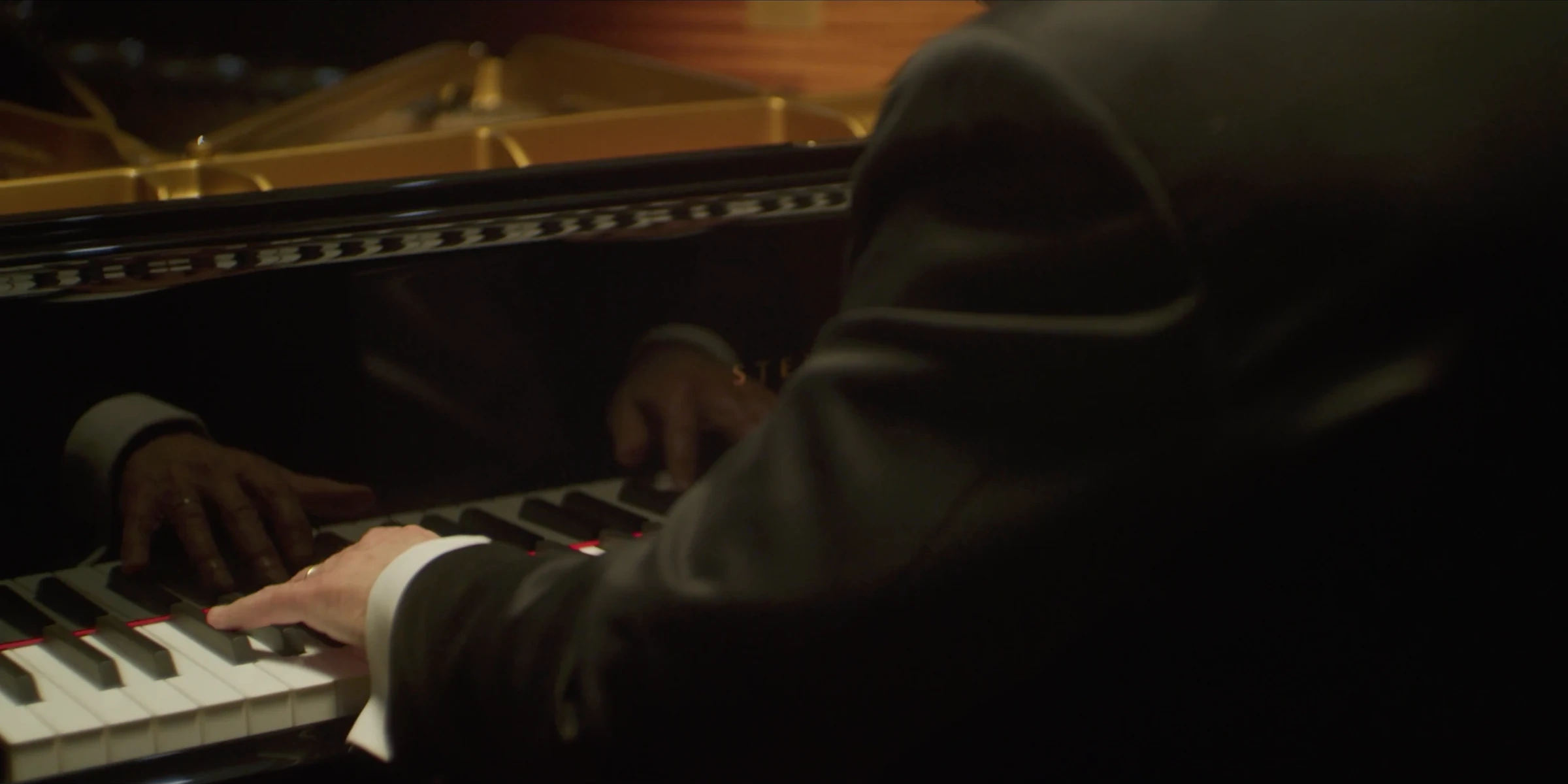 Piano keys and reflected hands