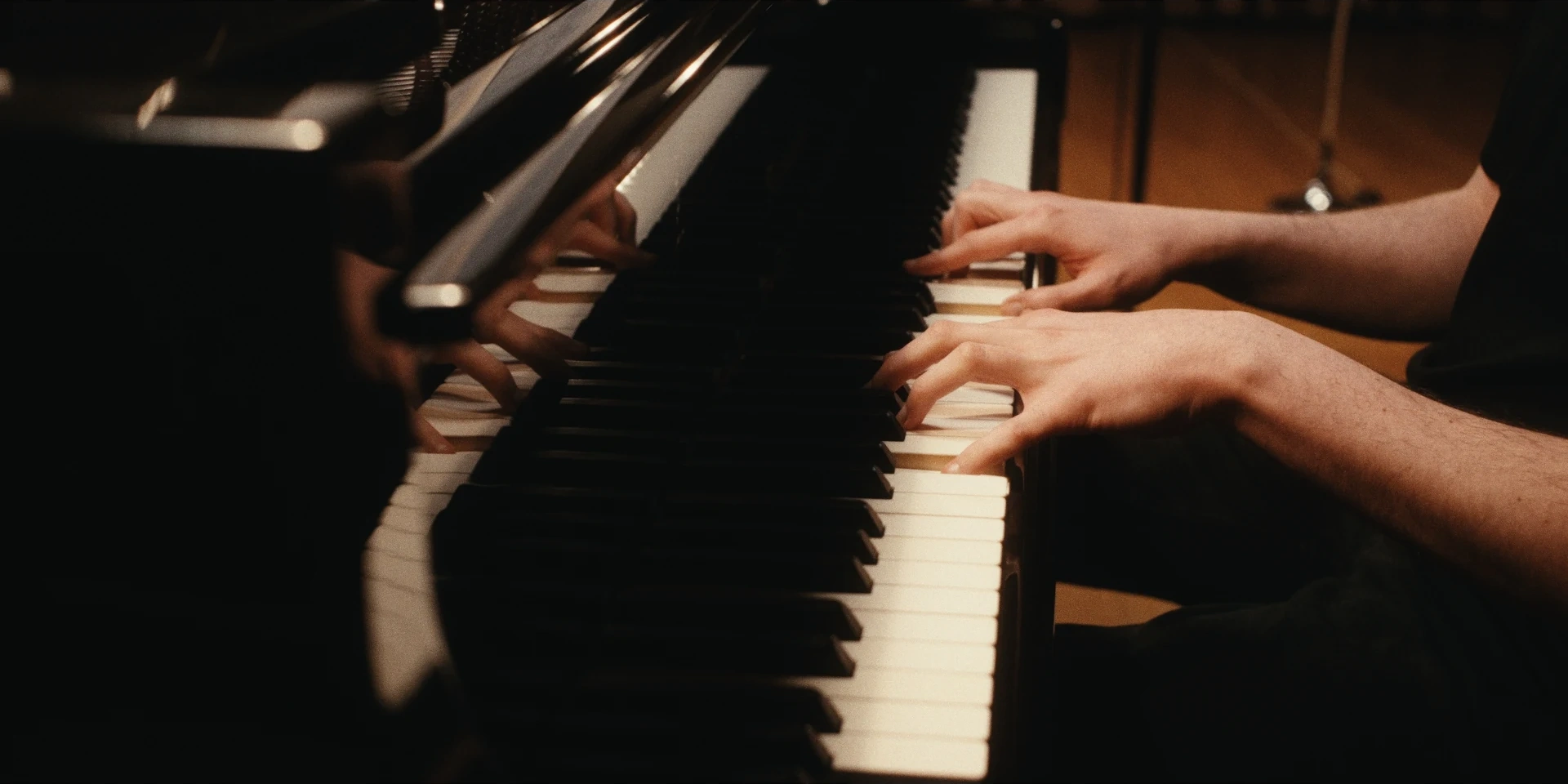 Piano keys and reflected hands