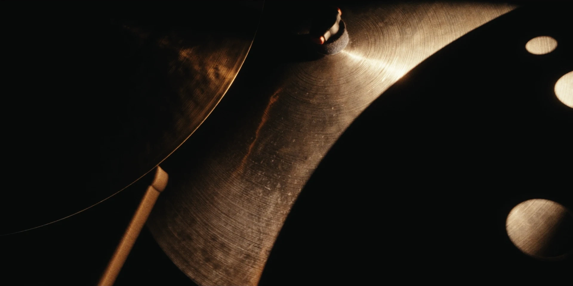 Golden light across the textures of overlapping cymbals