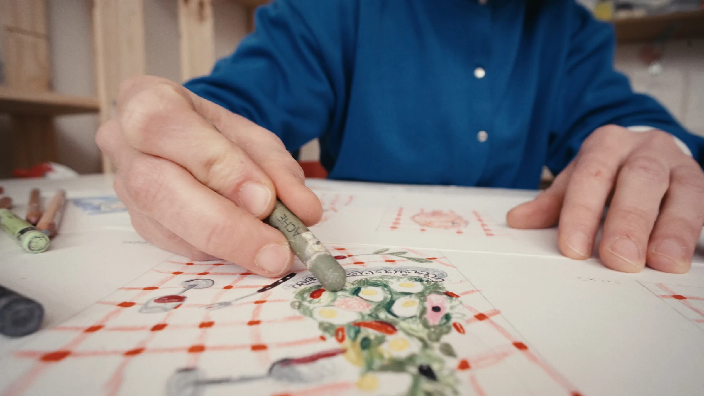 Hands drawing a still life with pastels