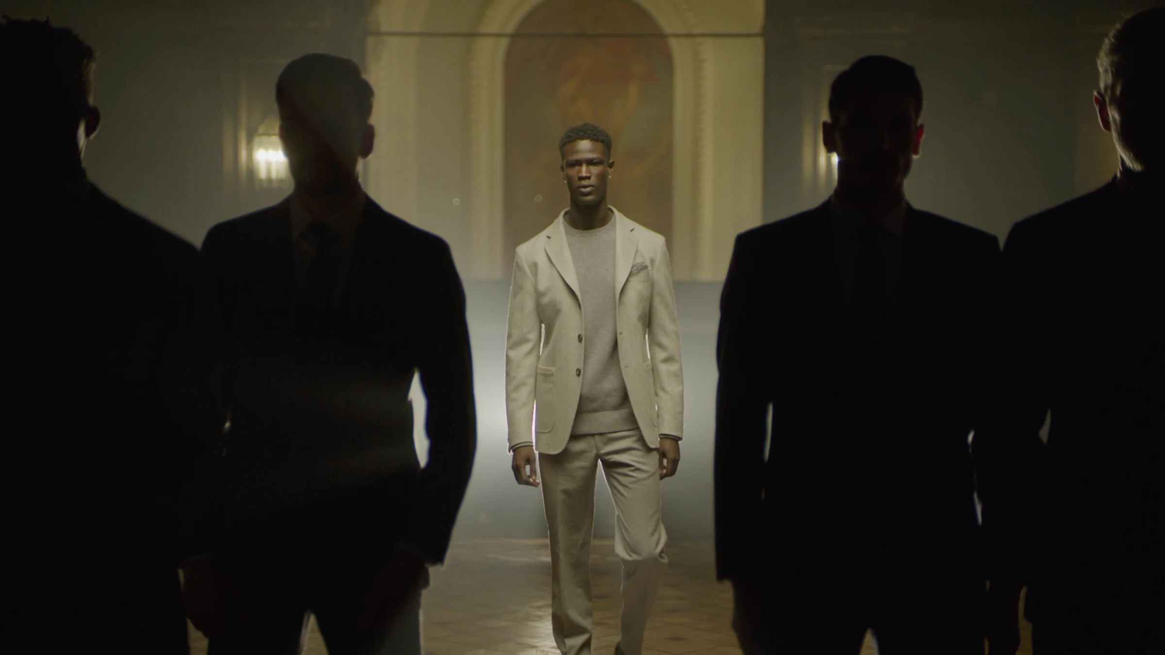 Model in a light suit framed by silhouettes