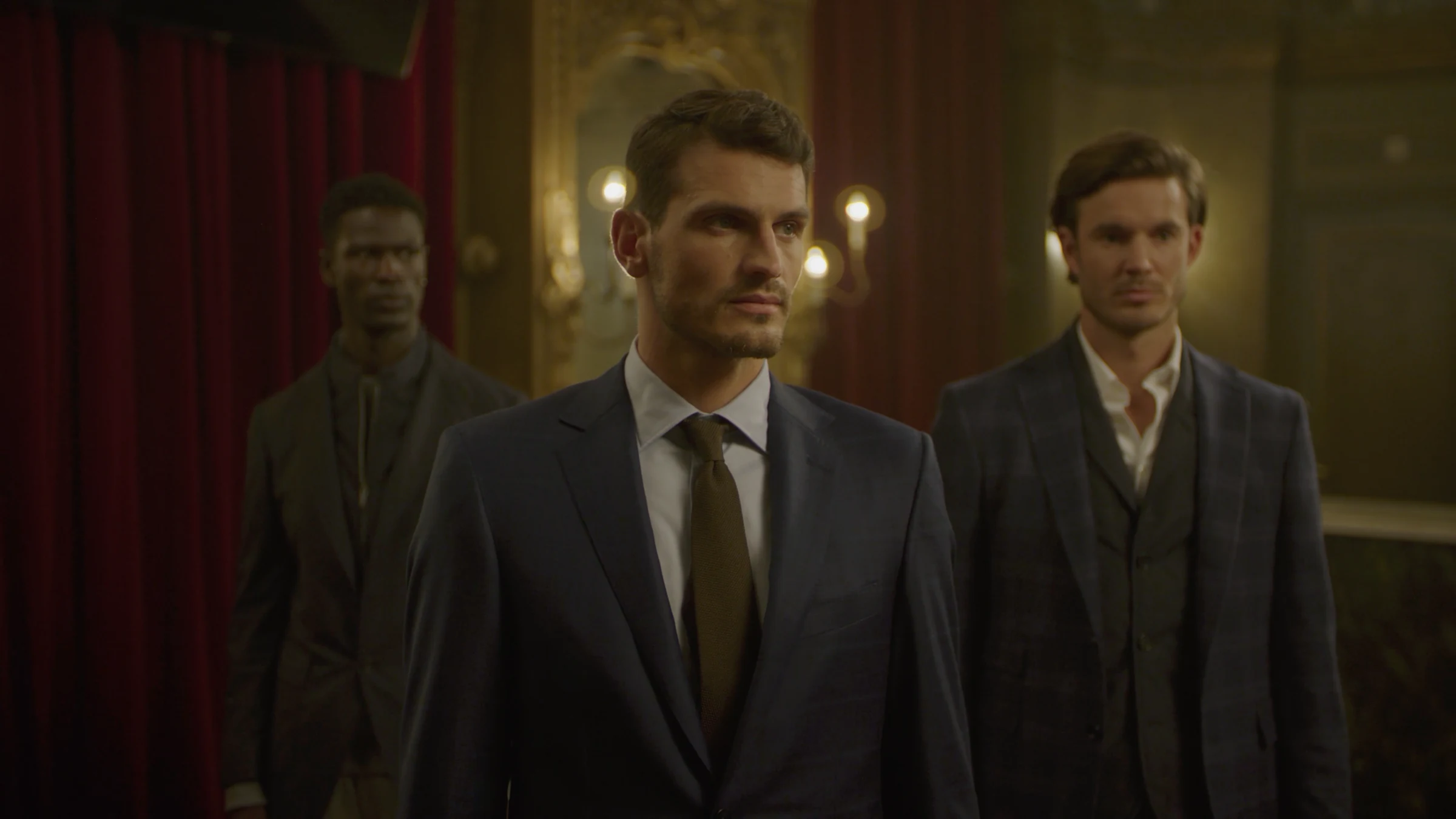 Three models in dark tailored suits