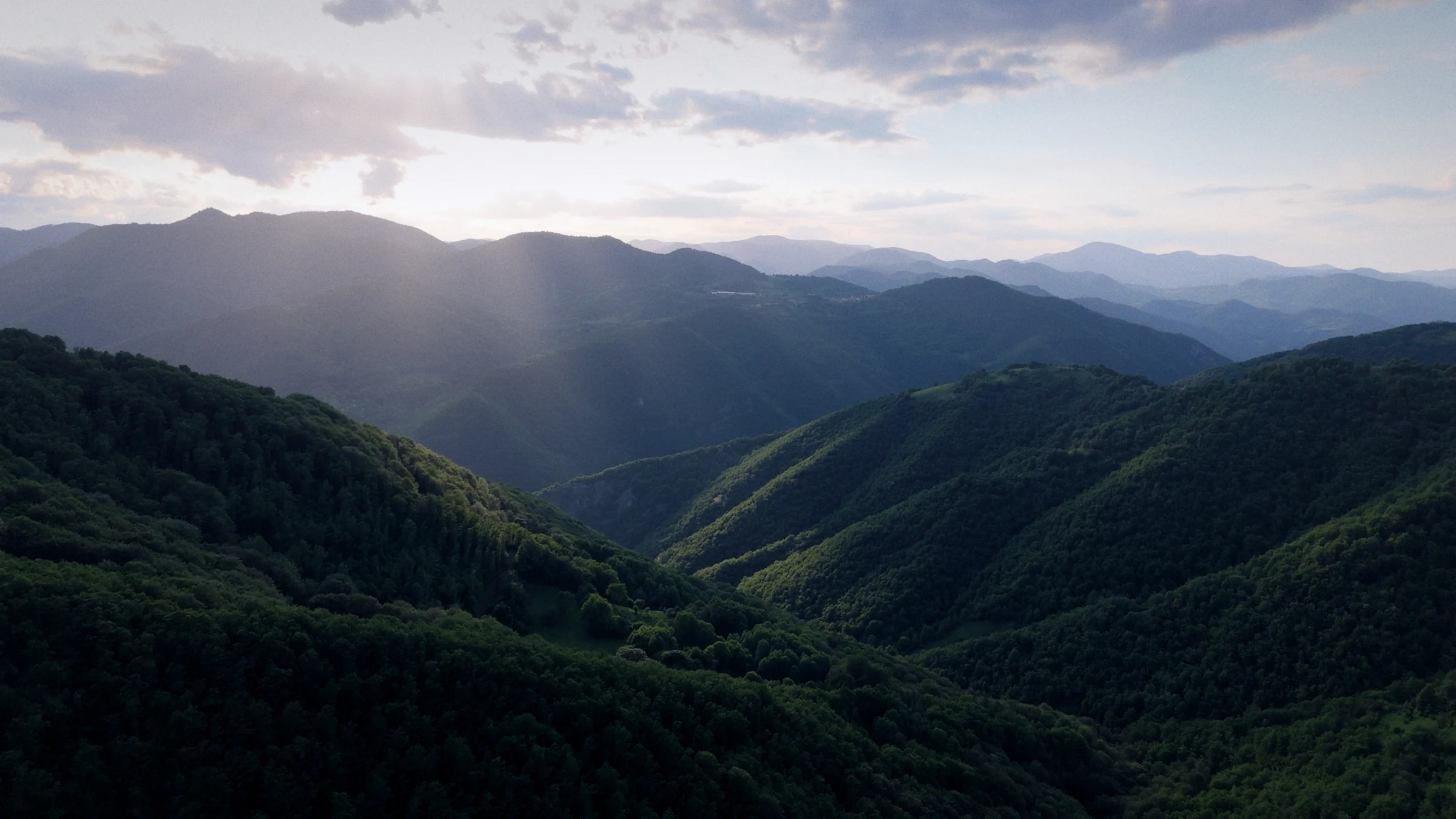 Evening light across layers of forested mountains