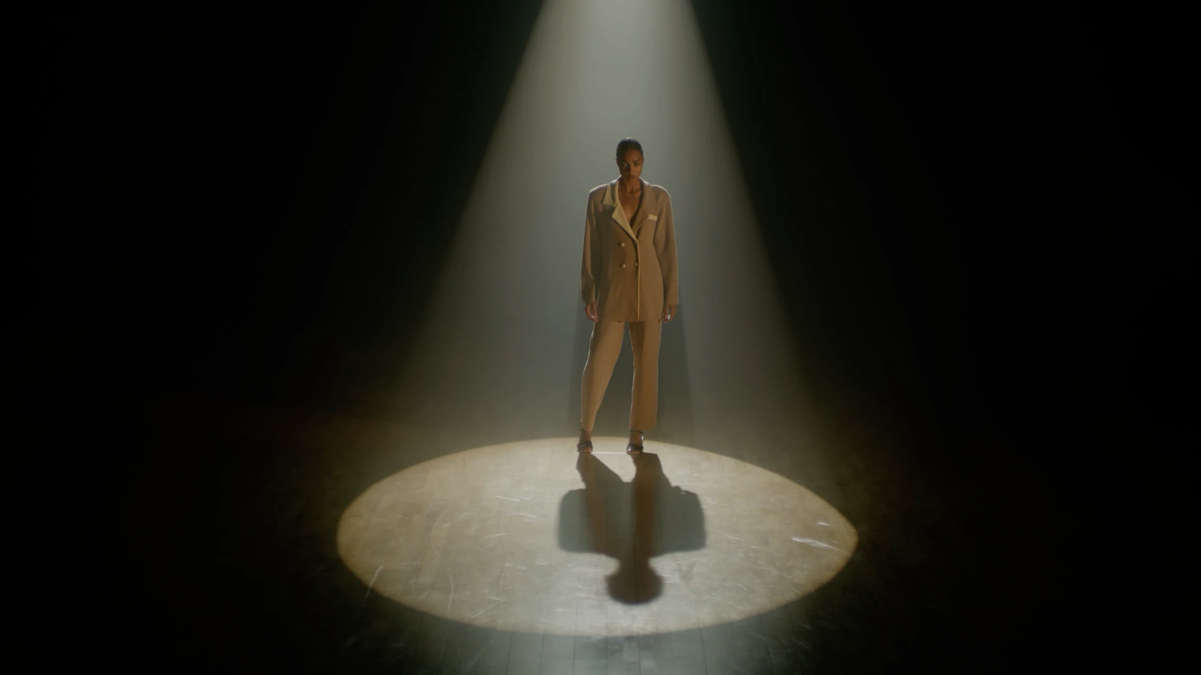 Model in a tailored suit beneath a spotlight