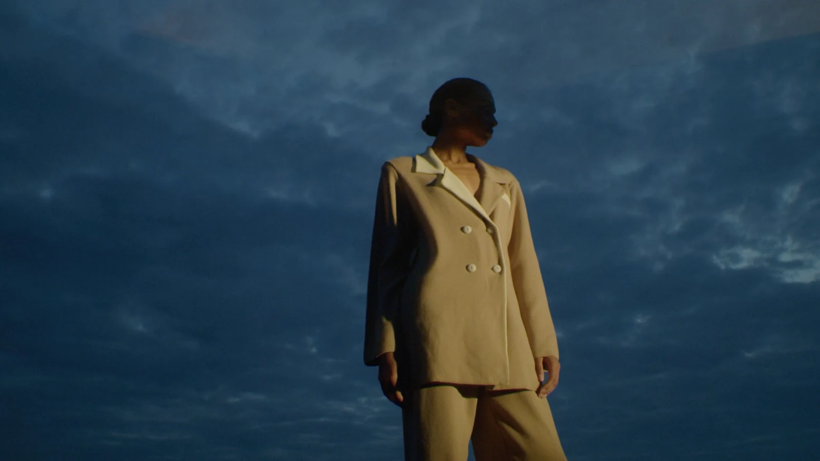 Valentine Witmeur — golden tailoring against a blue evening sky