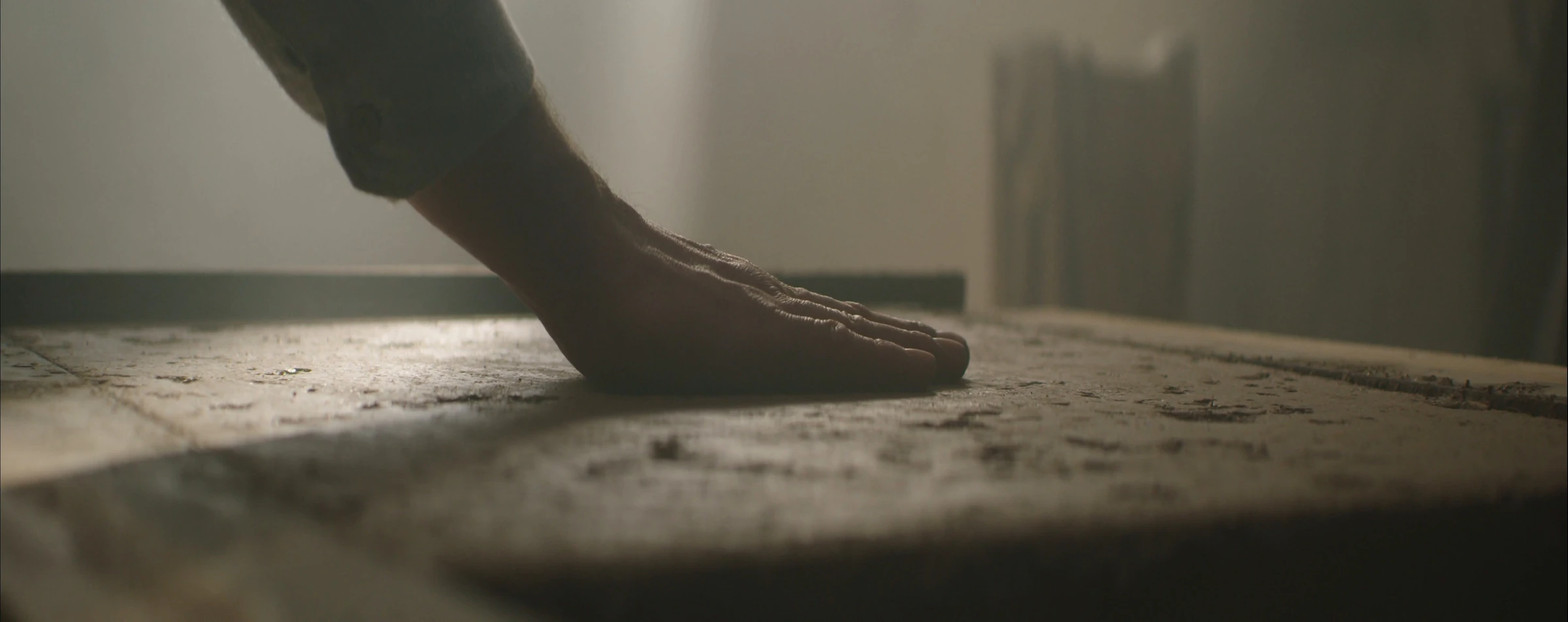 A hand feeling the rough surface of wood